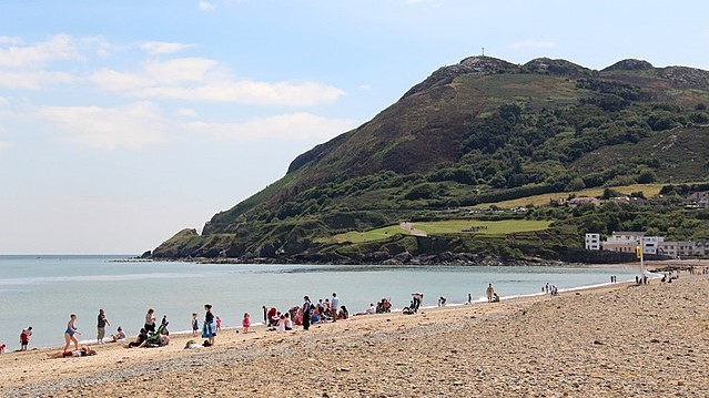 A cliff top beyond a stretching beach